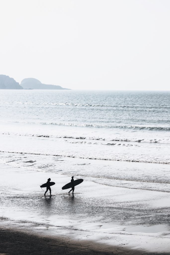 Image of two surfers walking into the ocean